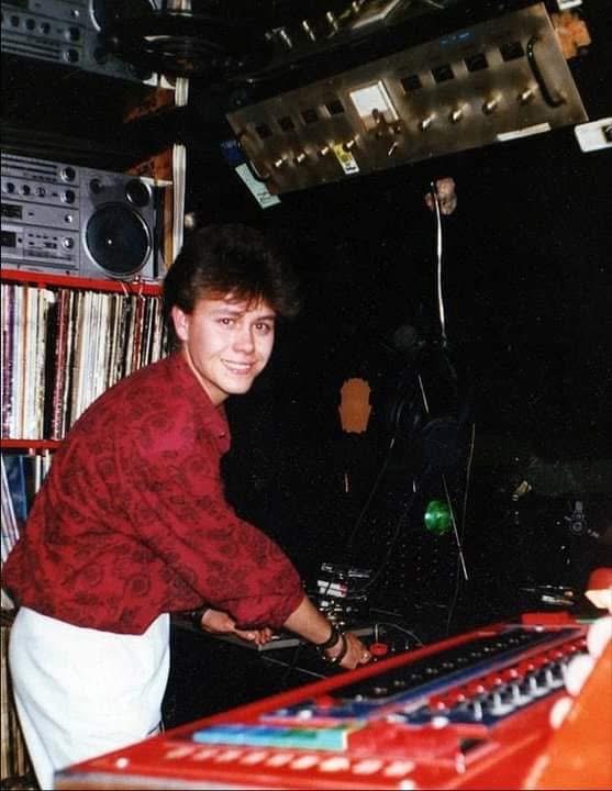 Disc jockey en la cabina de la Discoteca Armstrong rodeado de vinilos