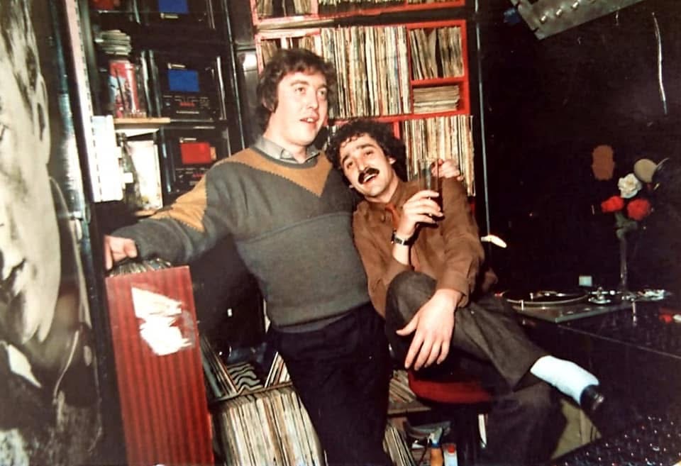 Dos disc jockeys posando en la cabina de la Discoteca Armstrong entre vinilos