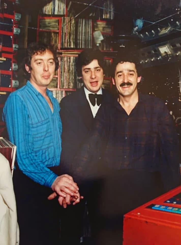 Tres hombres posando junto a la cabina de la Discoteca Armstrong